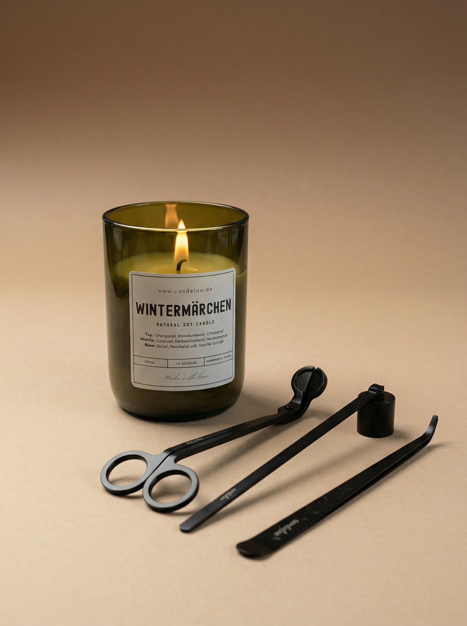 Handgemachte Wintermärchen Duftkerze aus Sojawachs von Candelae mit Kerzenpflege-Set aus Dochtschere, Löscher und Pinzette auf warmem Studiohintergrund