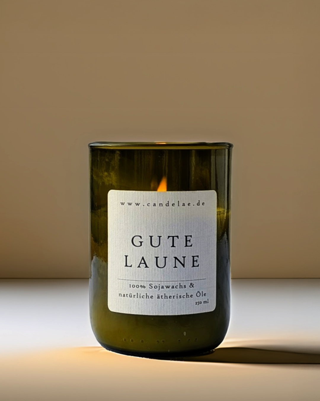 Candelae Duftkerze „Gute Laune“ – 250 ml Sojawachs in grünem Glas aus recycelter Weinflasche, mit ätherischen Ölen, handgemacht im Studio-Setup.