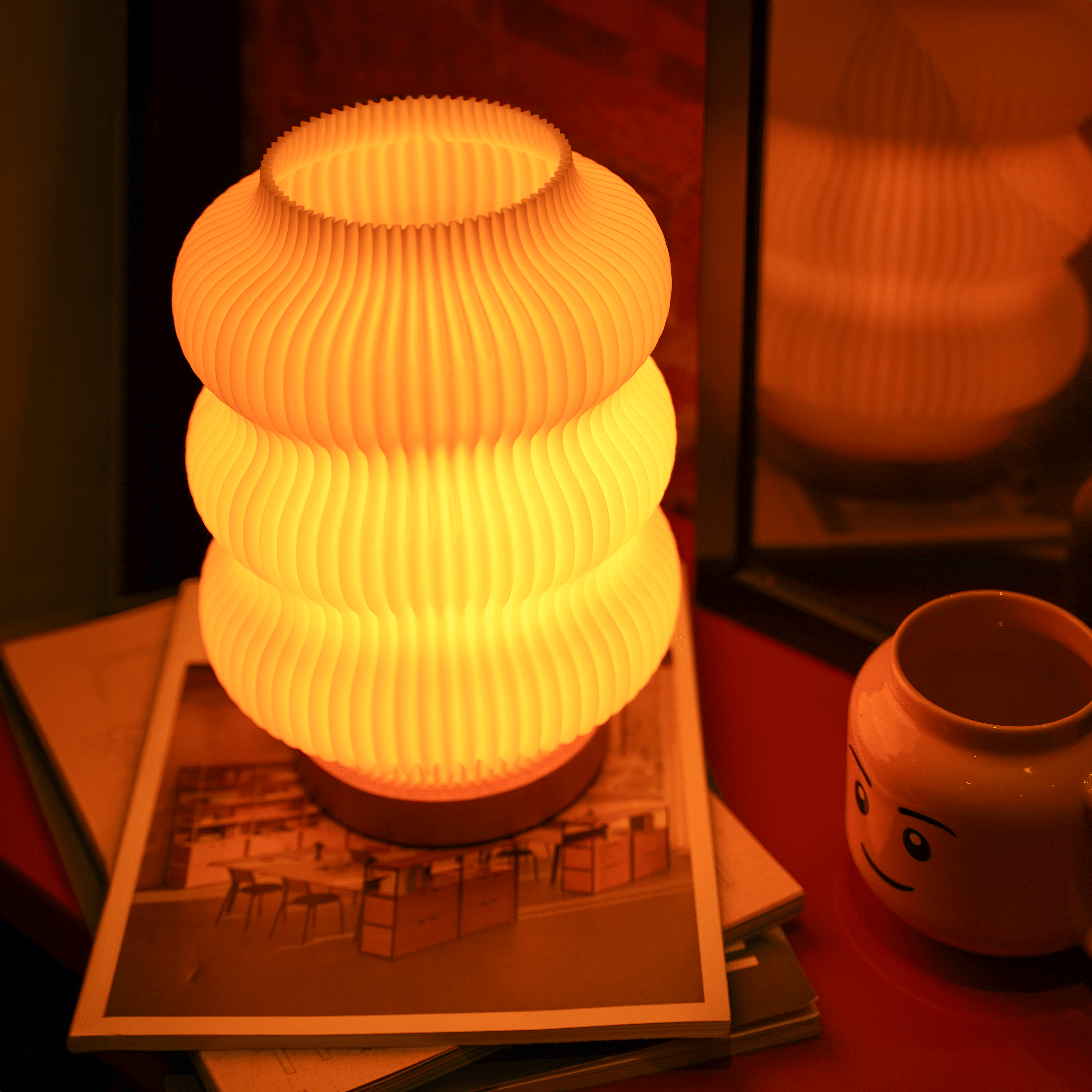 Moonou Luma 3D-gedruckte Tischlampe mit Wellenstruktur und Eichenholz-Sockel, warmes Licht mit Spiegelreflexion auf einem Tisch