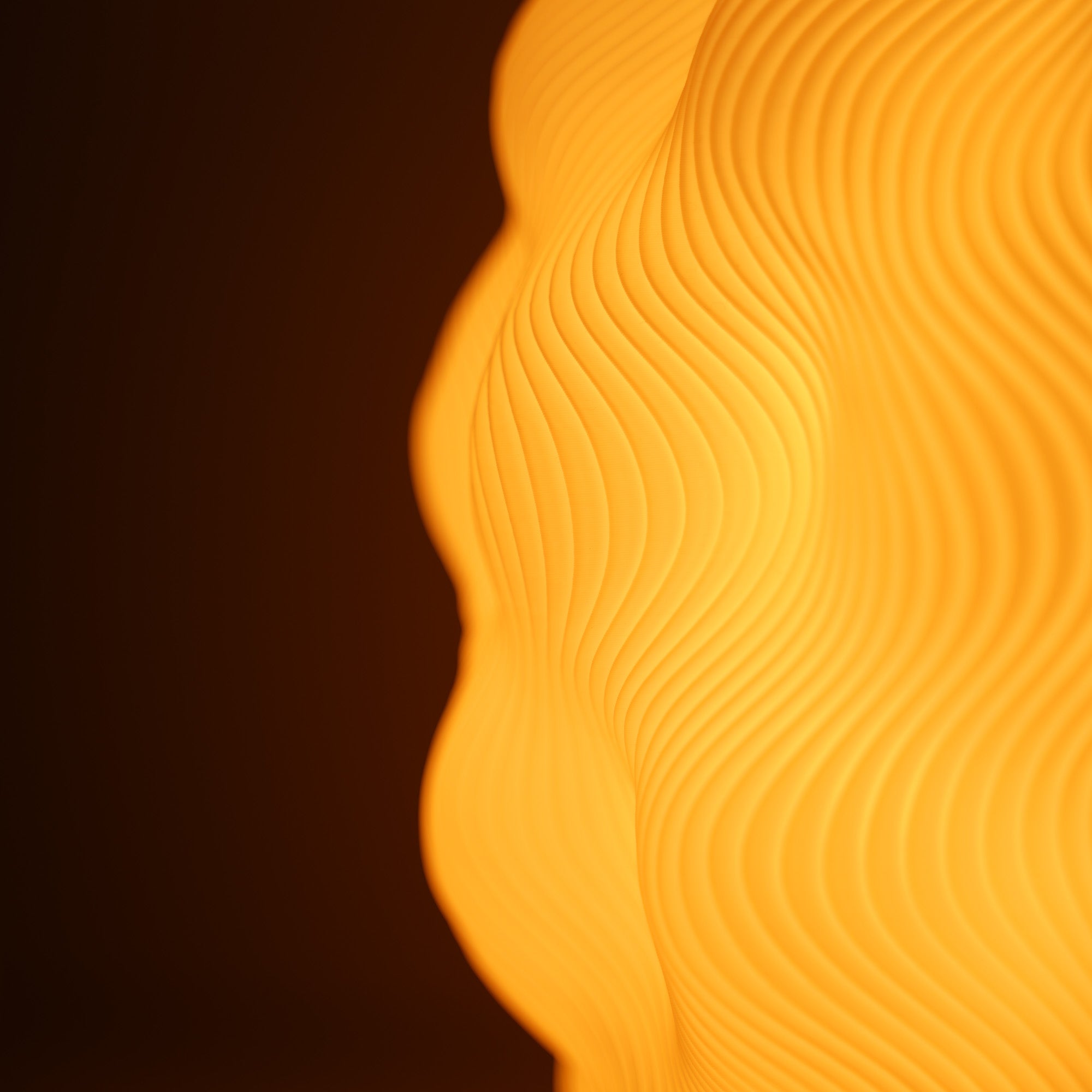 Detailaufnahme der Moonou Numo Tischlampe: beleuchteter 3D-gedruckter PLA-Lampenschirm mit organischer Wellenstruktur in warmem Licht (E27).
