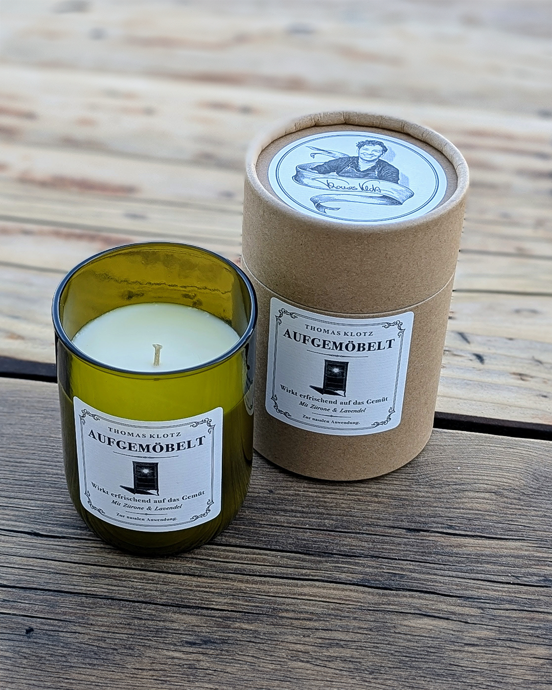 „Aufgemöbelt“ Duftkerze (Thomas Klotz × Candelae) – Sojawachs, Zitrone & Lavendel im Weinflaschen-Glas; Runddose mit Illustration und Signatur auf dem Deckel.