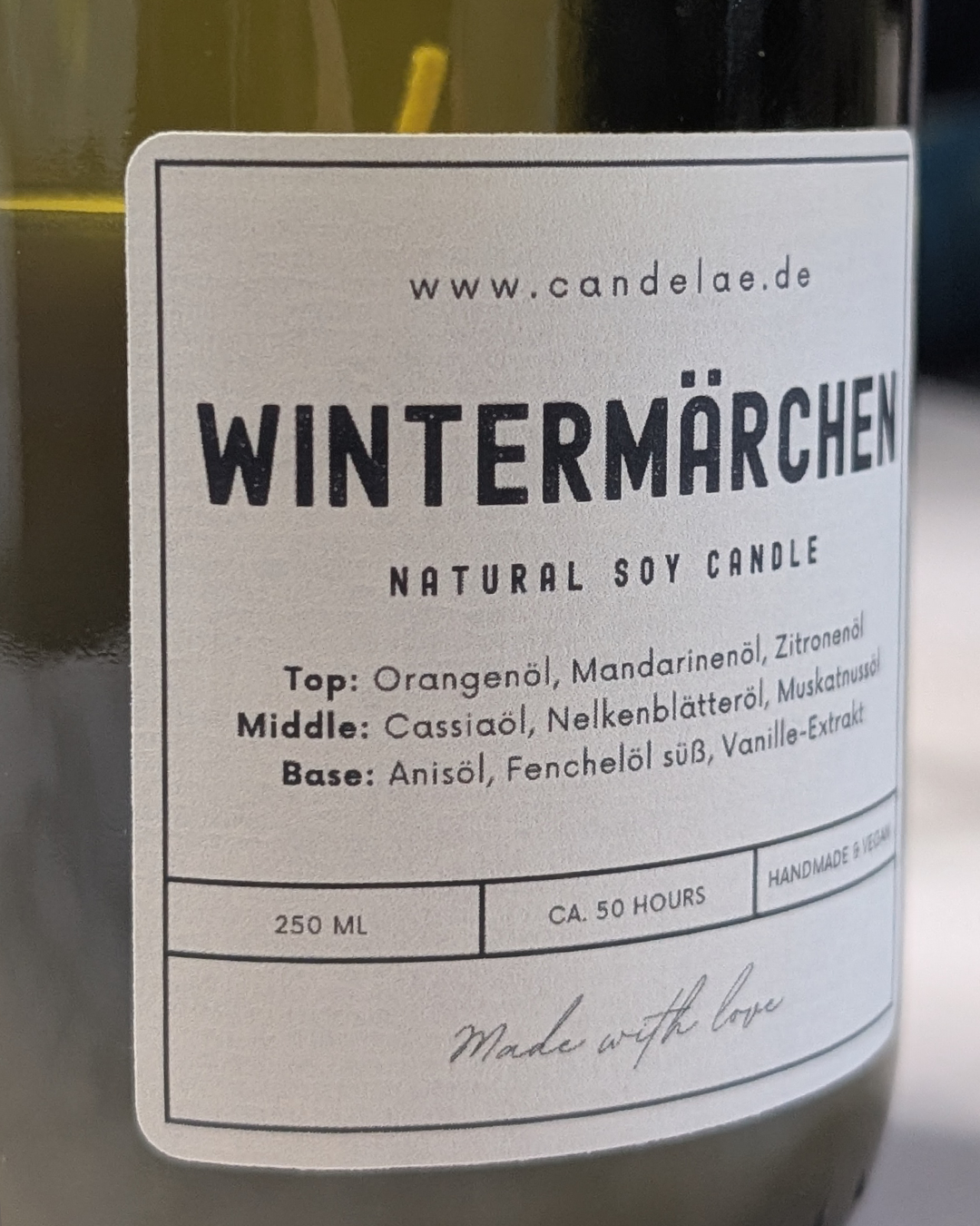 Nahaufnahme des Wintermärchen-Apothekerlabels auf der Sojawachs-Duftkerze von Candelae mit Duftnoten Orangenschale, Cassia und Vanille.