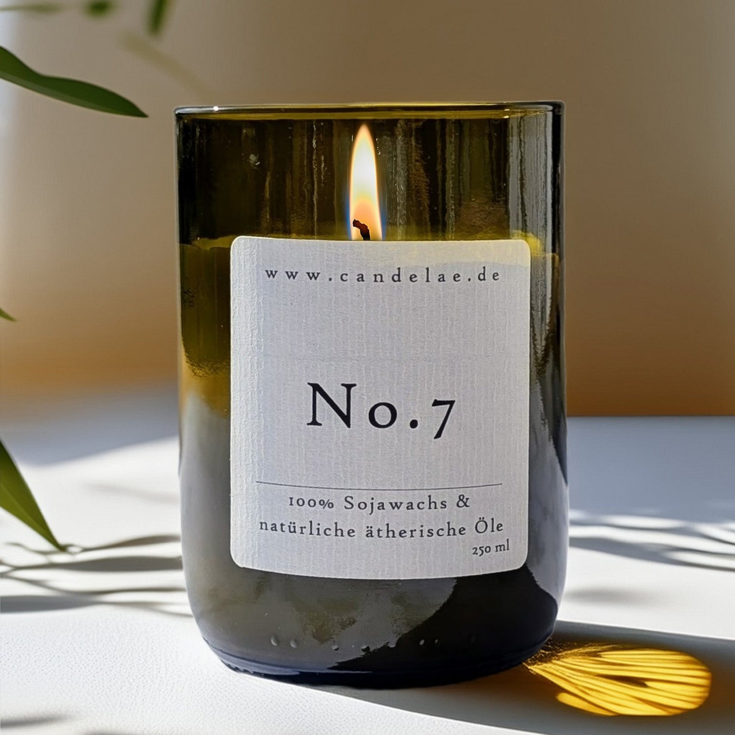 Vegane Duftkerze No.7 von Candelae aus recycelter Weinflasche mit natürlichem Sojawachs und ätherischen Ölen, brennend im Sonnenlicht.