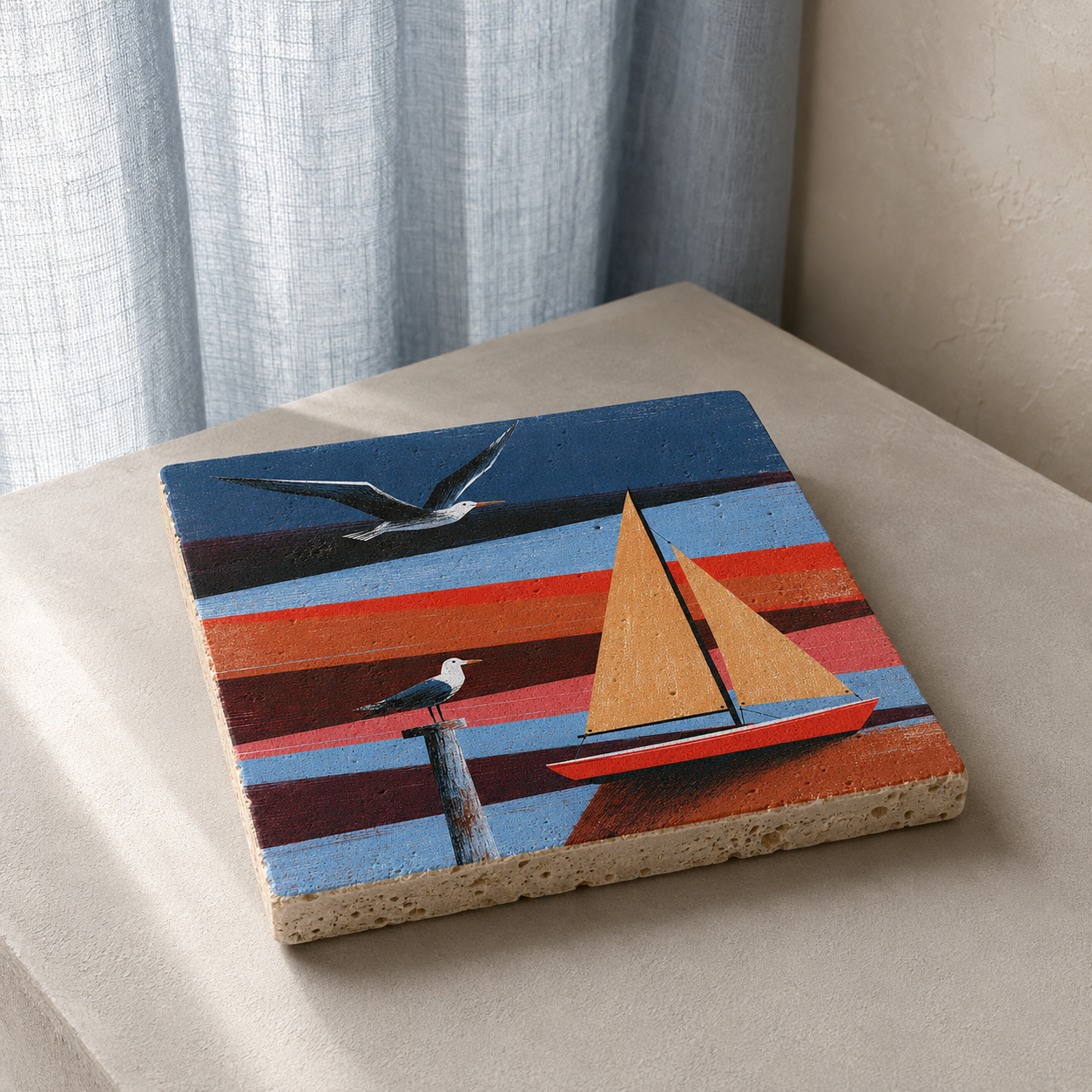 Kleines Kunstwerk aus Travertin „Küstenfreiheit“ mit rotem Segelboot und zwei Möwen auf einer hellen Konsole.