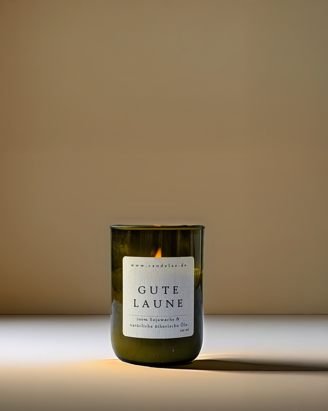 Candelae Duftkerze „Gute Laune“ – 250 ml Sojawachs in grünem Glas aus recycelter Weinflasche, mit ätherischen Ölen, handgemacht im Studio-Setup.