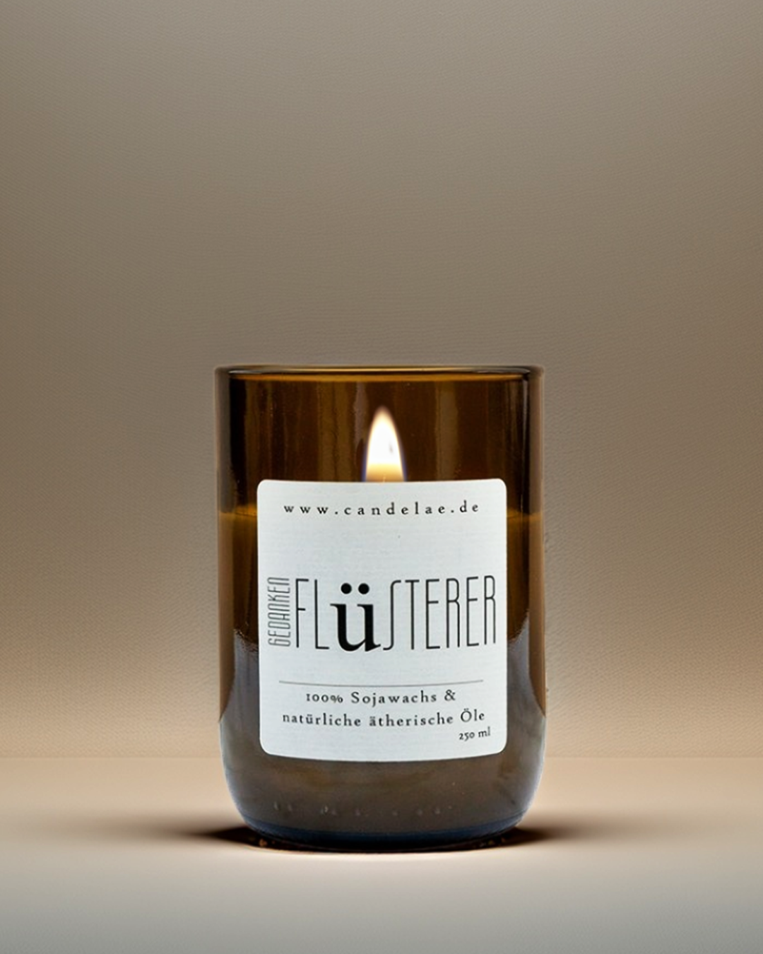 Brennende Candelae Duftkerze „Gedankenflüsterer“ – 250 ml Sojawachs im recycelten Weinflaschen-Glas, mit natürlichen ätherischen Ölen auf warmem Studiobackground.
