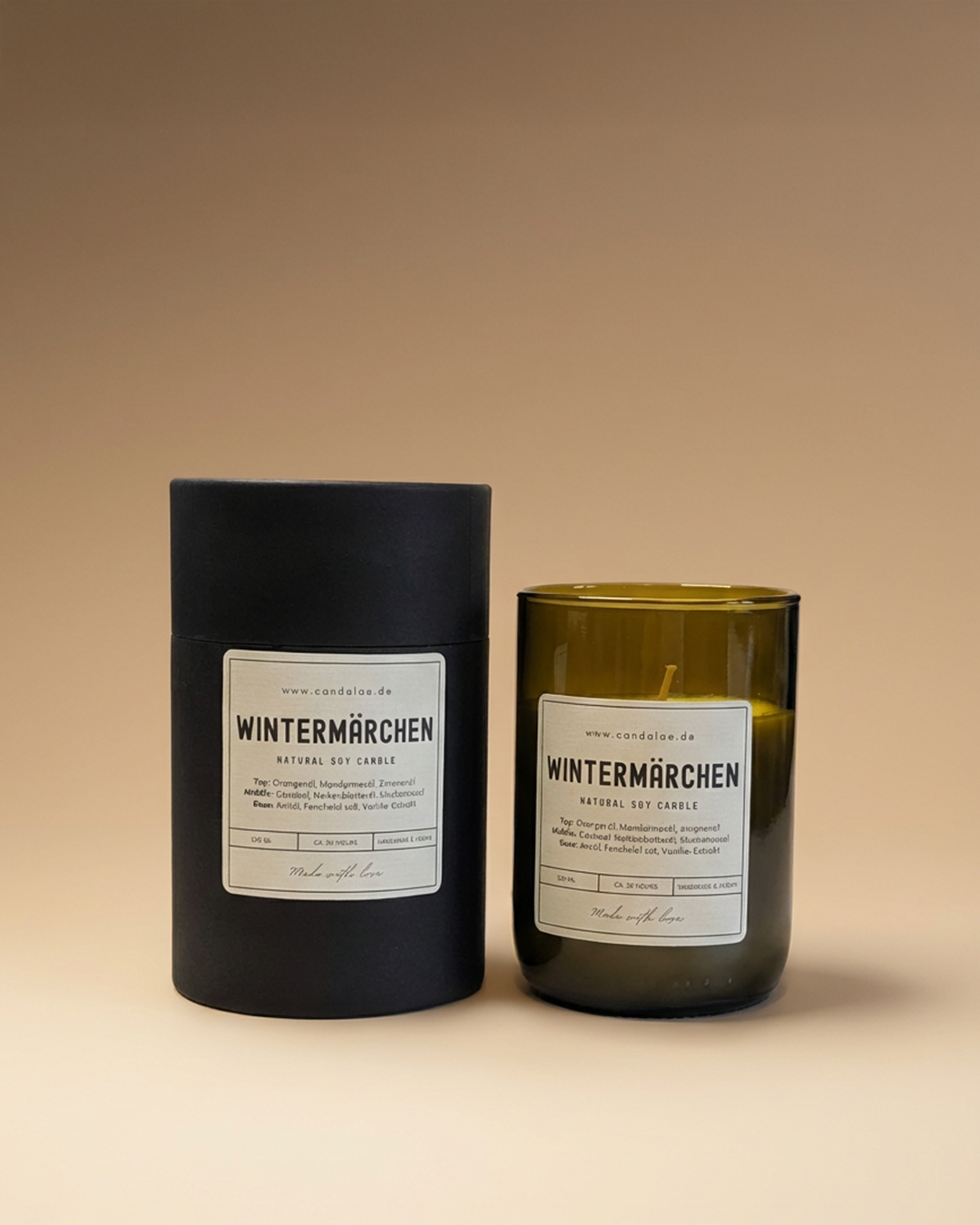 Wintermärchen Duftkerze von Candelae mit passender Verpackungsbox im Apothekerlabel, fotografiert auf warmem beigen Studiohintergrund.