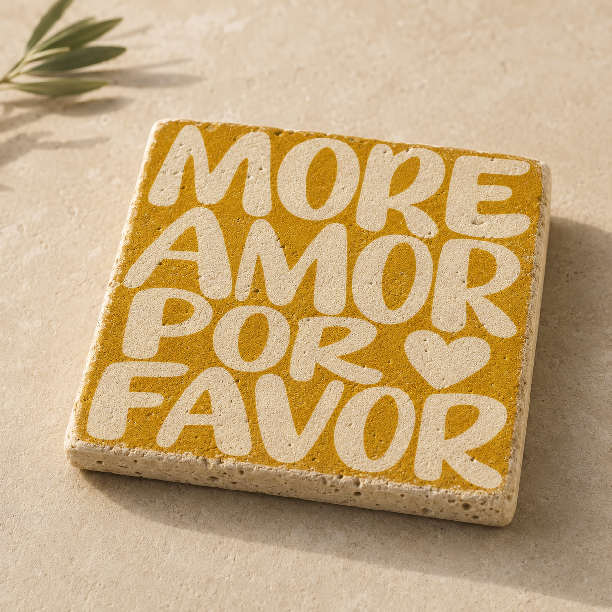 Kleines Travertin-Kunstwerk mit cremefarbenem Schriftzug „More Amor Por Favor“ auf senfgelbem Grund.